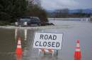 A driver manages to drive through flood waters from the Snohomish River in Snohomish, Washington, on Dec. 11, 2025. Tens of thousands of people were under evacuation orders Thursday in western North America, after days of heavy rain forced rivers to burst their banks. Storms have battered Washington state in the US and British Columbia over the Canadian border for several days, with rivers continuing to rise. (Jason Redmond / AFP via Getty Images)