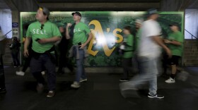 Fans walk inside of the Oakland Coliseum, before a baseball game between the Athletics and the Tampa Bay Rays in Oakland, Calif., Tuesday, June 13, 2023. (AP Photo/Jed Jacobsohn)