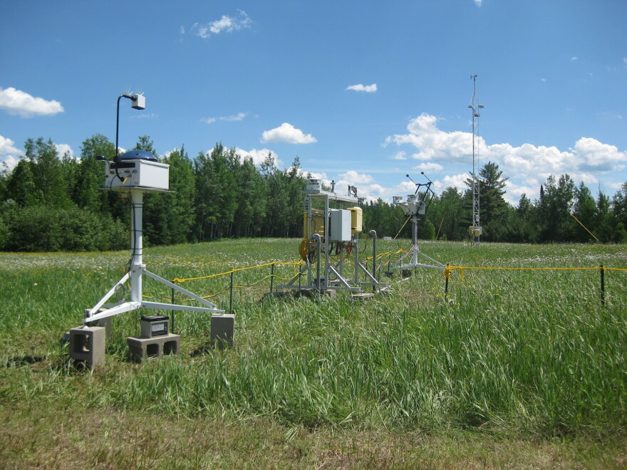 Weather observation equipment with cumulus clouds in the background.