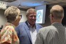 Man speaks to a pair of supporters 