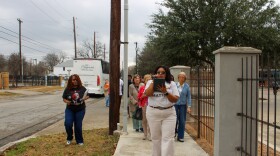 SAAACAM Docent Mackenzie Wilson guides guests off the bus toward the Carver Community Cultural Center.