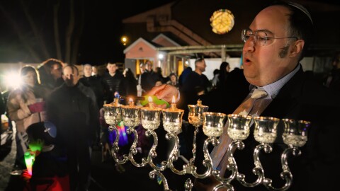 Tuvia Brander , Rabbi of the Young Israel of West Hartford, lights a menorah on the fourth day of Chanukah. About a hundred people attended the event. Said Brander, “Especially over the terrible events that we saw in Sydney and really around the world of late, coming together to be proud Jews and supporters of the Jewish community is something that I think is so important. It builds community resilience. It's a sign and it's a symbol for all of us, both people, externally, but I think as much for each of us here that we're not going to be scared off by people who want to increase darkness in the world, and that's what Hanukkah is all about, lighting lights to dispel the darkness.”