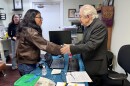 Eliza Perez (right), the daughter of respected community leader Olga Perez, shakes hands with Father Frank O’Loughlin, an Irish-born Roman Catholic priest, after an emotional prayer ahead of a scheduled online deportation hearing for Olga. | March 18, 2026
