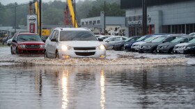 Manchester, CT - August 22, 2021: Cars drive through a portion of Route 83 in Manchester that was flooded by tropical storm Henri. (Tyler Russell/Connecticut Public)