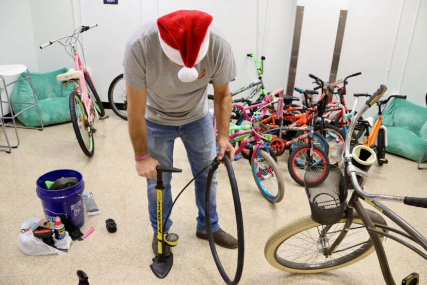 Robert Cass pumps up an inner tube for one of the bikes he is restoring with a Norfolk nonprofit to donate to young people.