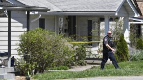 A Louisville Metro Police officer walks outside of the home of the suspected shooter in the Camp Taylor neighborhood in Louisville, Ky., Monday, April 10, 2023. Police say a 23-year-old armed with a rifle opened fire at his Louisville workplace, the Old National Bank in downtown Louisville, killing and wounding several, and was killed by police responding to the shooting. (AP Photo/Timothy D. Easley)