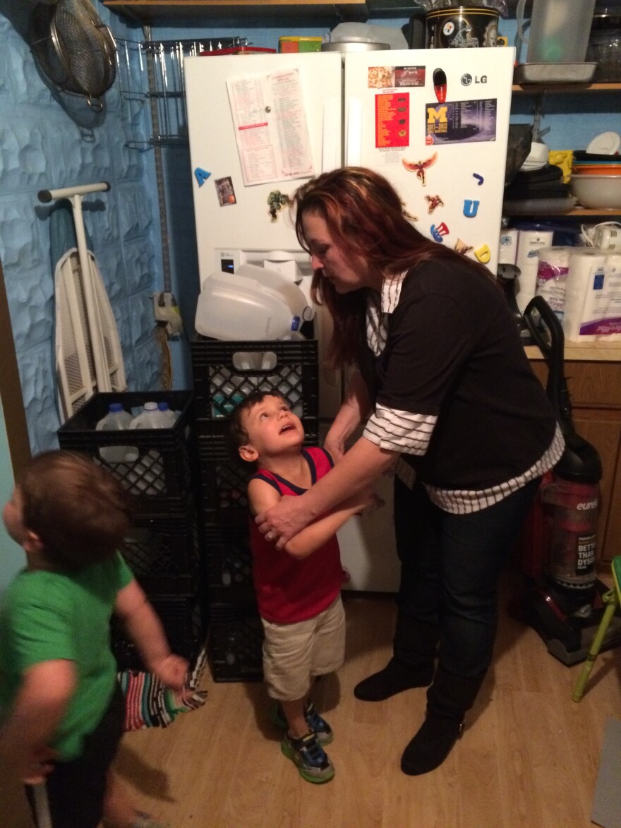 Lee Anne with her twin boys Garrett and Gavin. Note the crates of bottled water by the refrigerator.