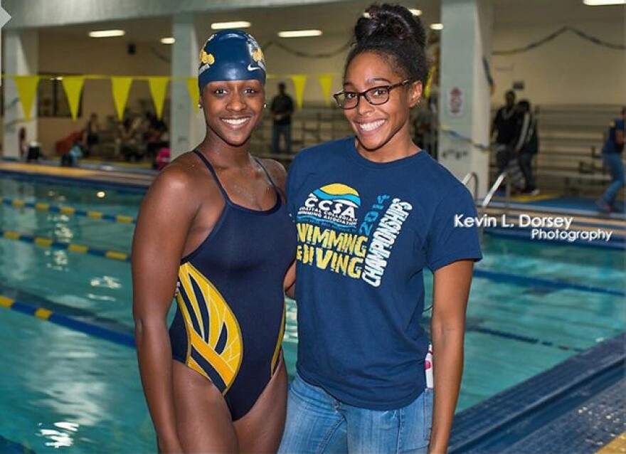 Swimmers Emani Davies, left, and Dominique Crable, right, pose for a photo near a pool.