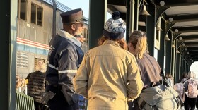 An Amtrak employee directs passengers to board the Heartland Flyer