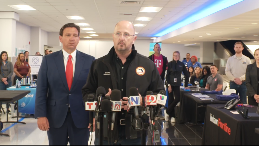 The governor and FDEM Director Kevin Guthrie address the press ahead of a flight carrying 14 Floridians from Haiti touches down in Sanford on Wednesday night. 