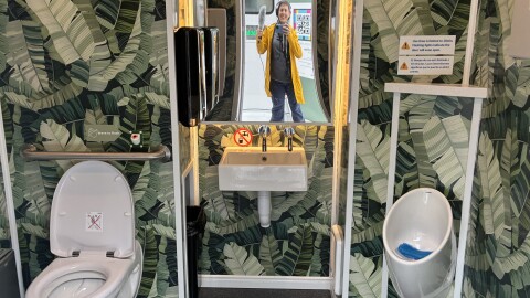 Bathroom selfie! KUOW reporter Anna Boiko-Weyrauch poses with her microphone and commemorates a successful trip to the Throne toilets in Pioneer Square, May 15, 2026. 