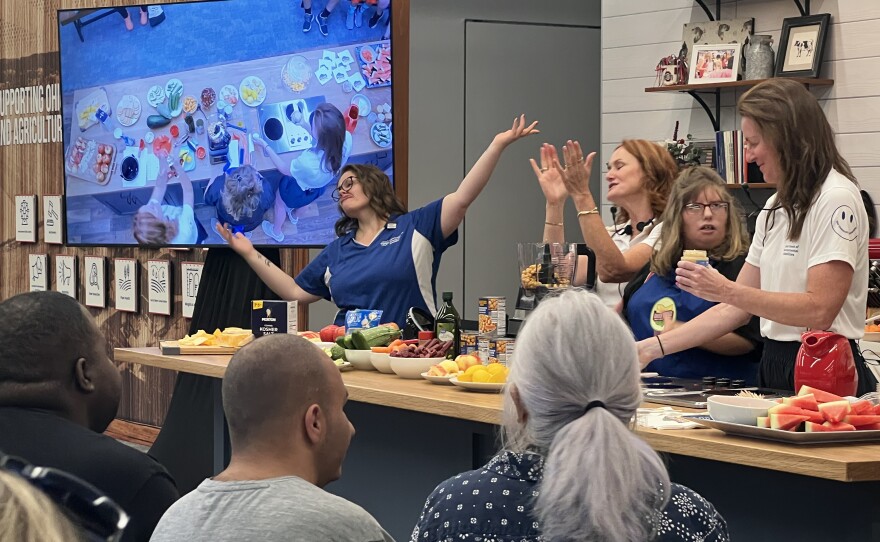 Audience members applaud and watch as the Ohio Department of Developmental Disabilities leads a cooking demo in the Ohio Proud store