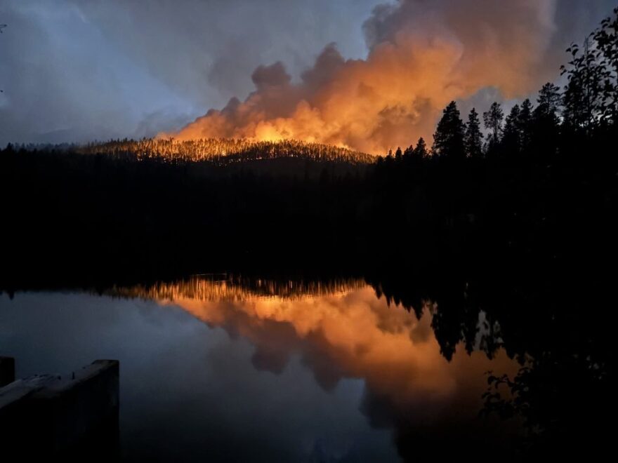 A large fire burns over a mountain during the night