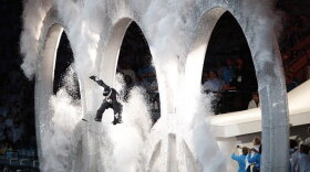 A snowboarder jumps through the Olympic rings during the opening ceremony.