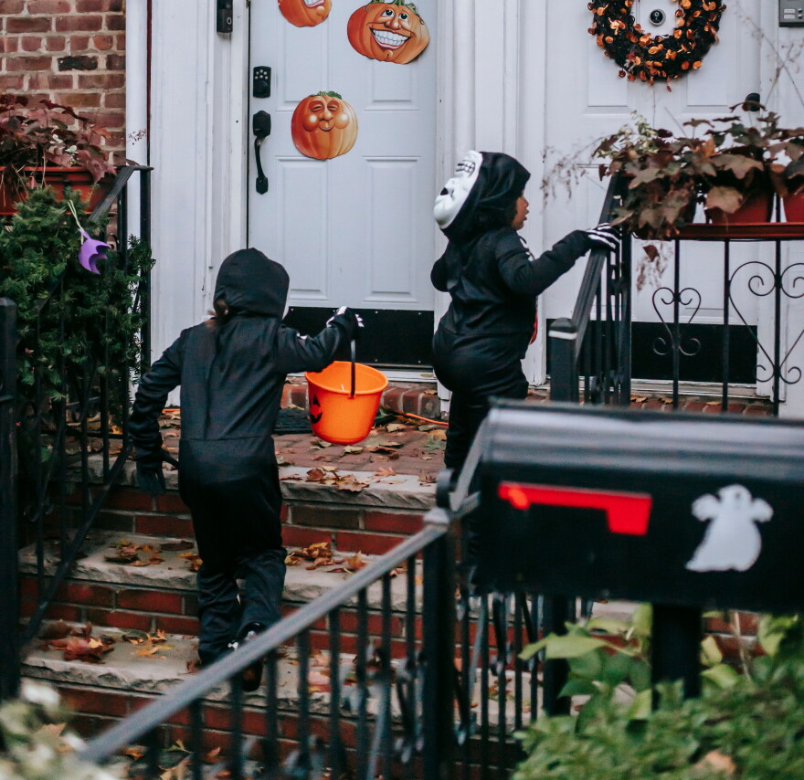 Trick-or-treaters go door to door on Halloween.