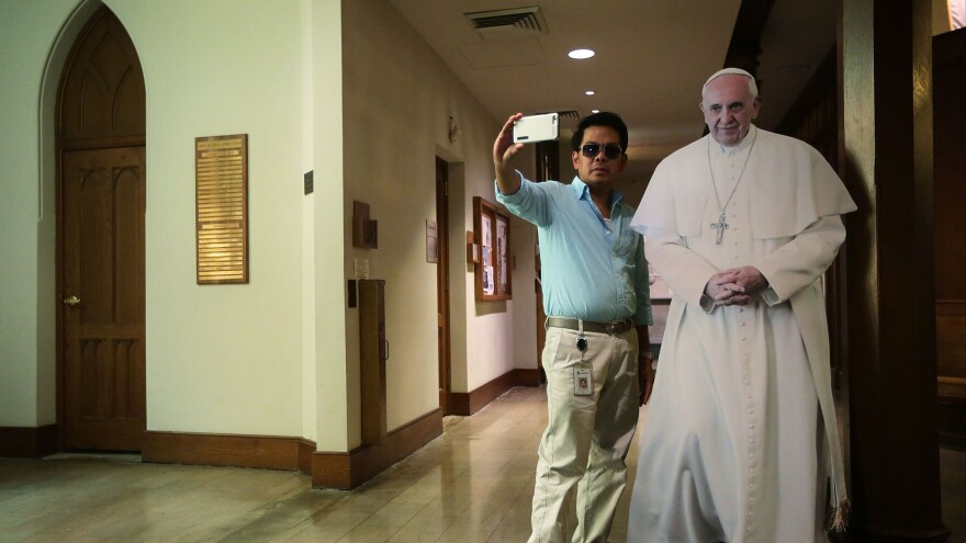 A visitor takes a selfie with a cardboard cutout of Pope Francis at St. Patrick's Catholic Church in Washington, D.C., on Sept. 16.