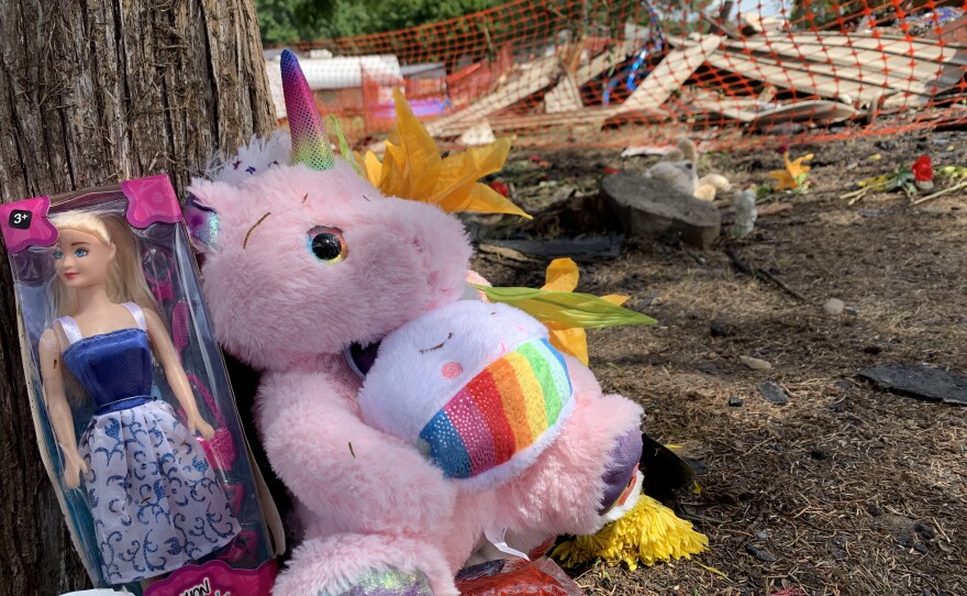 Toys are left at a memorial to victims of a fatal fire. 