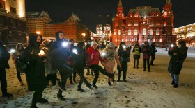 Young people dance shining their cellphone flashlights in support of jailed opposition leader Alexei Navalny and his wife Yulia Navalnaya near Red Square in Moscow on Sunday.