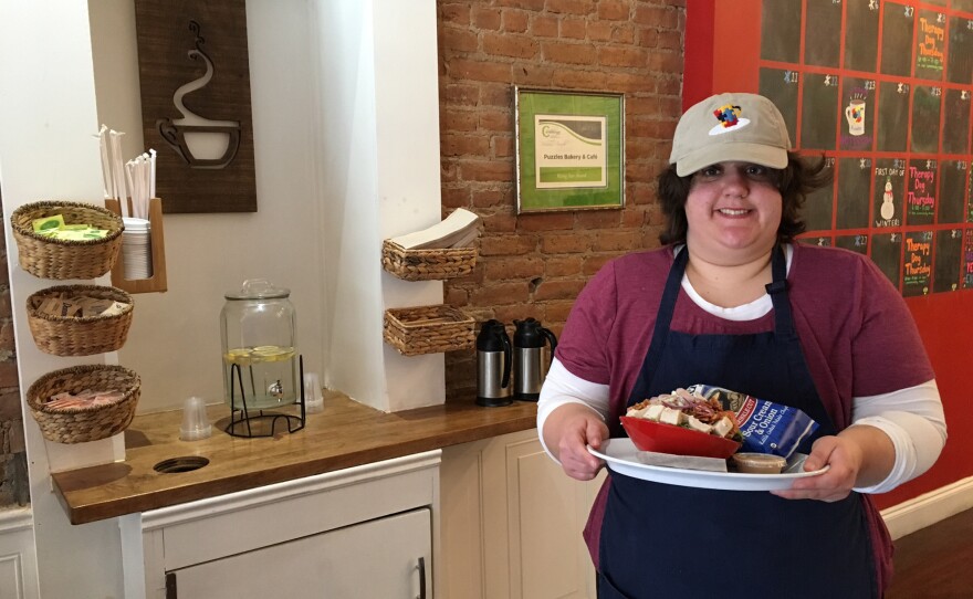 Madaline Hannon, 23, a café attendant at Puzzles takes a sandwich to a customer. Hannon has autism. Her parents say the job has helped her become more social and independent.