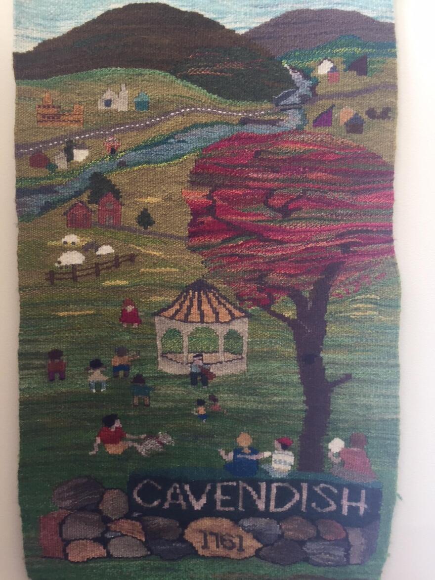 The Cavendish community tapestry which shows a river, tree, gazebo and townspeople and says Cavendish 1761.