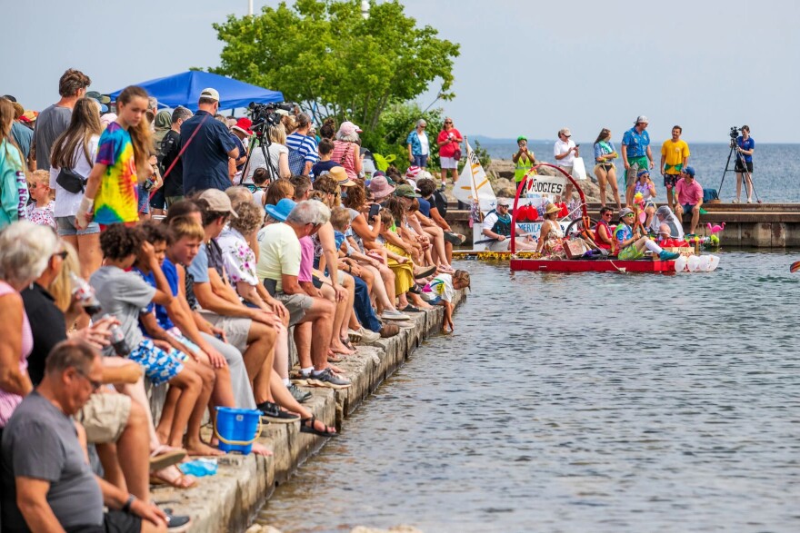 A crowd watches the National Cherry Festival’s Milk Carton Regatta at the Clinch Park Marina Boat Launch on Wednesday morning in Traverse City. Competitors raced boats made from recycled milk cartons on a course just off shore of Clinch Beach.
