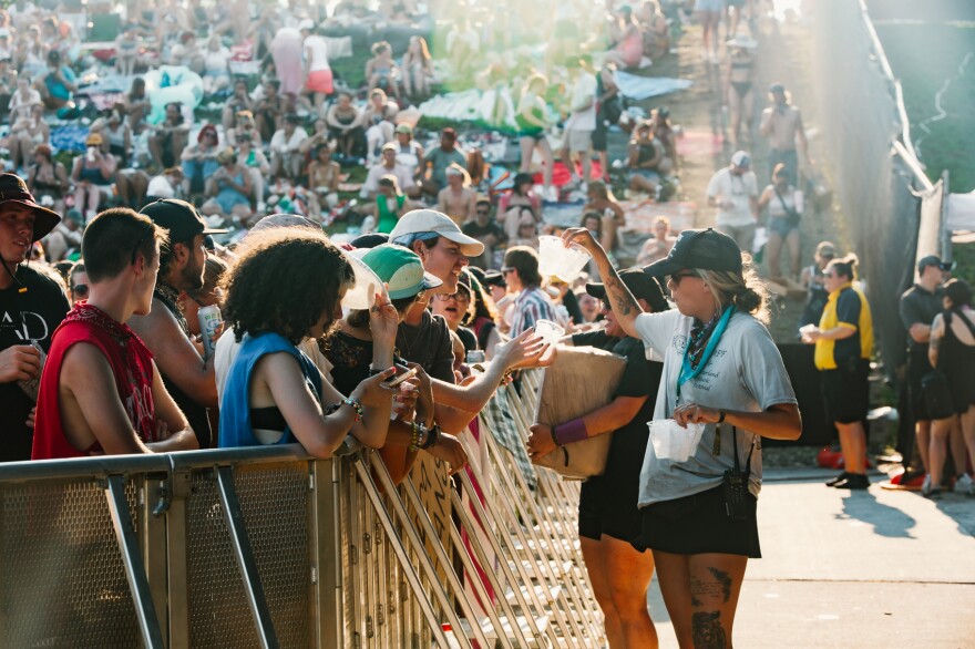 A festival staff member hands out ice to the crowd awaiting the next set at Hinterland in 2024.