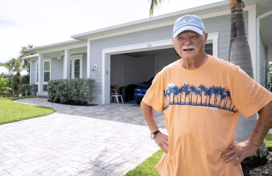 Jim Delaney with a smile on his face while standing in front of his home.