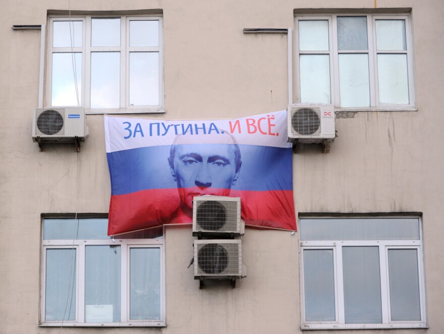A portrait of Russian prime minister and presidential candidate Vladimir Putin, bearing the slogan "For Putin! And That's It!" hangs on a building in Moscow.