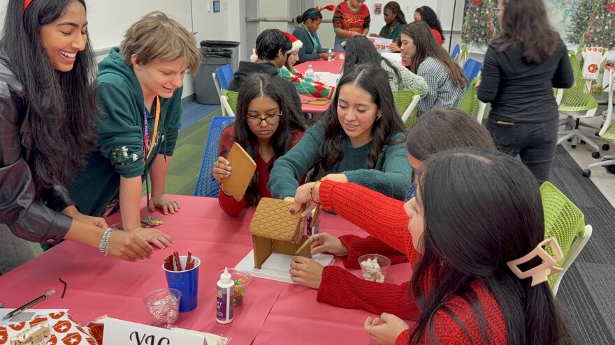 Youth Leadership Council (YLC) members worked together in teams to build a gingerbread house during their annual holiday social, highlighting teamwork and creativity.