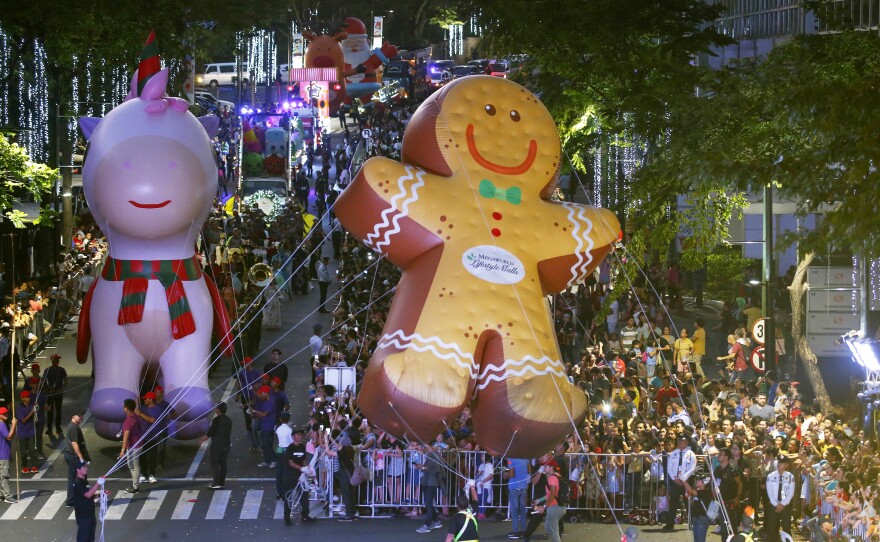 Hundreds of residents watch as colorful floats and larger-than-life balloons, including the "Happy Pink Unicorn" and the "Giant Ginger Bread," are paraded ahead of the Christmas celebration at a shopping area in greater Manila, Philippines, on Dec. 8.