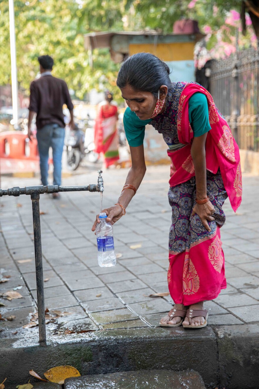 A woman fills a bottle from the tap at the Seth Gangalal V. Mulji Nandlal fountain. Researchers and water rights activist say the pandemic has exacerbated the huge inequality in Mumbai's water supply, with lower-income families struggling to find affordable and safe water.