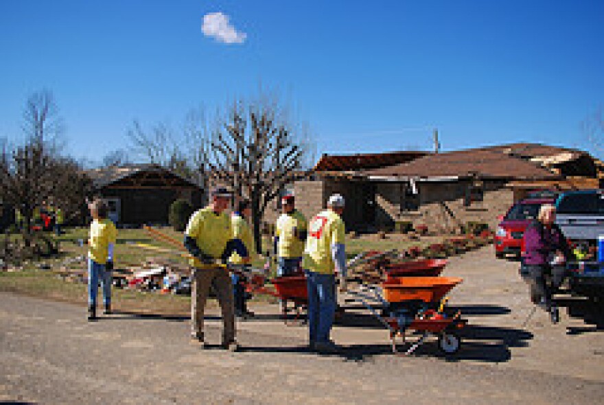 Aid workers and ordinary citizens work together in the aftermath of the tornado that tore through Muhlenberg County last February.