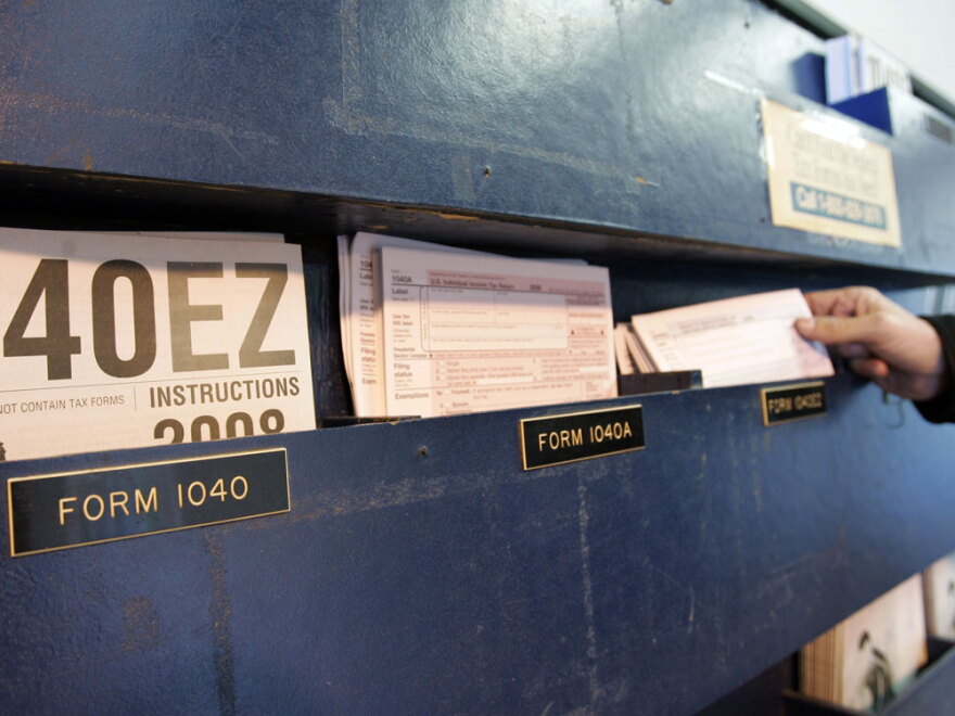 A man picks up federal tax Form 1040 at a post office in Palo Alto, Calif., last April. Some of the wealthiest people in the U.S. want to pay higher taxes to help reduce the deficit.