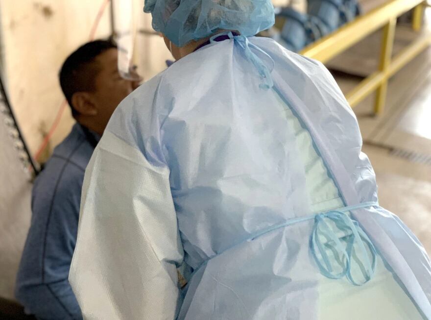 A health care worker from Klamath Health Partnership performs a nasal test on a farmworker at Planasa in Klamath County.