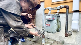 Todd Saddler (front) and Laurie Konwinski prepare to turn off the gas connection to their home in Itha