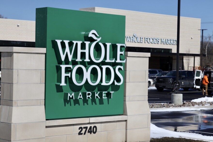 A Whole Foods sign with the street number, 2740, visible, and the building in the background.