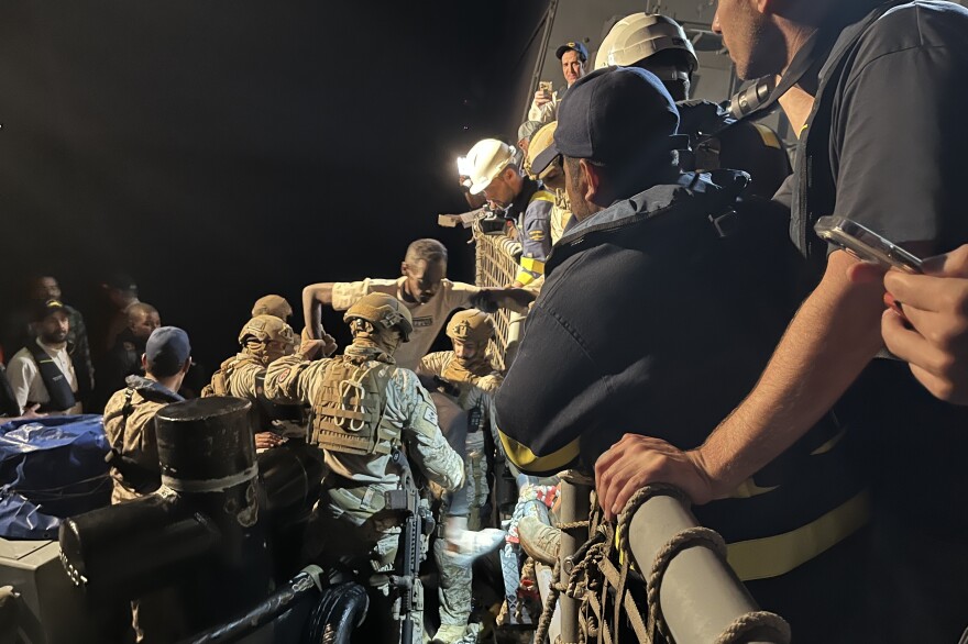 A man is assisted by Saudi commandos as he gets off a tugboat near Port Sudan and onto a Saudi warship that will travel across the Red Sea to Jeddah, Saudi Arabia. May ‎2, ‎2023.