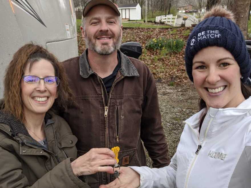 Melissa and Michael Nightingale from Paola, Kansas, handing the keys of their RV to Dr. Ashley Olson in Parkville, Missouri.