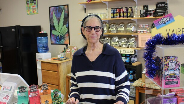Sharon Gordon, owner of Bloomer Botanicals in Winfield, stands at the counter in her shop. In the background and at the counter are several different kinds of consumable, hemp-derived products. 
