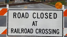A sign reads "Road Closed at Railroad Crossing"