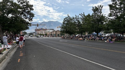 Road with people lined up on the side for parade.