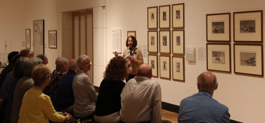 Dulce Roman, chief curator and curator of modern art at the museum, gives a tour to the visitors and explains to them about the work done by Francisco Goya. (Jose Sanchez/WUFT News)