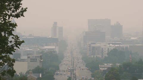 A wide-angled view of downtown Salt Lake City, Utah, blanketed in wildfire smoke, creating a hazy view of the city. 