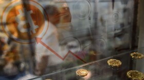 A man walks past a display cabinet containing models of Bitcoins in Hong Kong on Aug. 3, 2016. (Anthony Wallace/AFP/Getty Images)