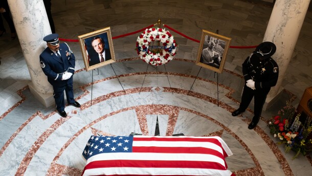 Two officers stand watch over a flag-draped casket.