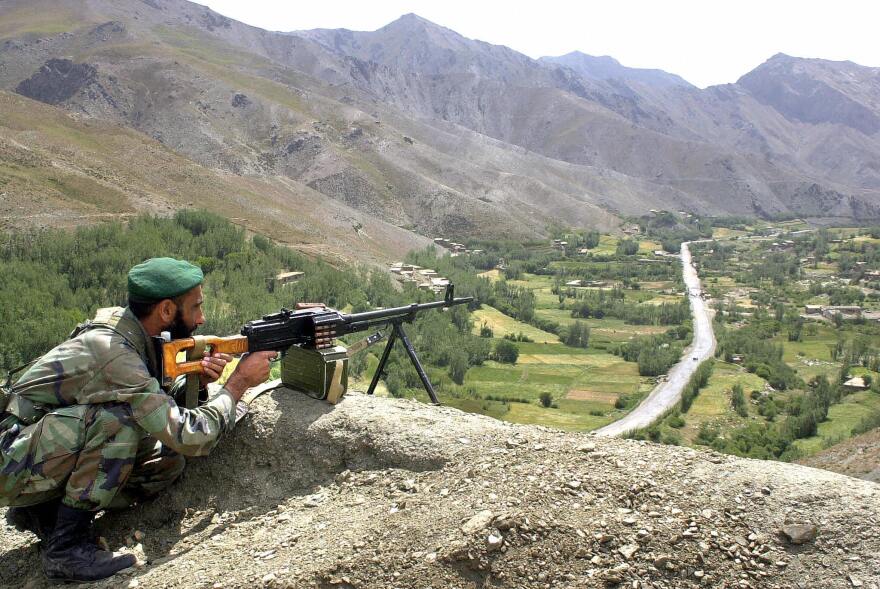An Afghan soldier keeps watch above a road leading to the Salang Tunnel during Afghan President Hamid Karzai's visit on Aug. 27, 2003.