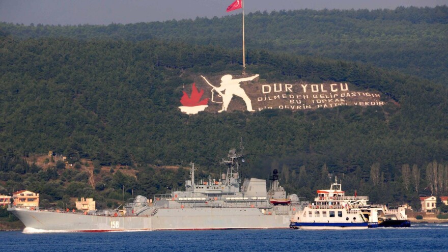 The Russian naval ship Caesar Kunikov passes through the Dardanelles strait in Turkey to the Mediterranean Sea on Sunday. The memorial on the mountain commemorates the World War I Gallipoli campaign, with a sign citing a Turkish poem: "Stop passenger. The land you come upon without knowing is the place an era had ceased." Russia began launching military operations in Syria last Wednesday.