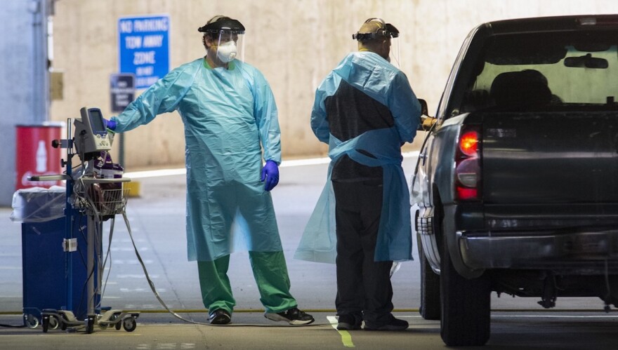 Health care providers offer COVID-19 testing at a drive-through at Baptist Health in Little Rock.