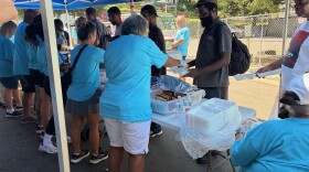Volunteers serve lunch outside at the Roof Above Day Center. 