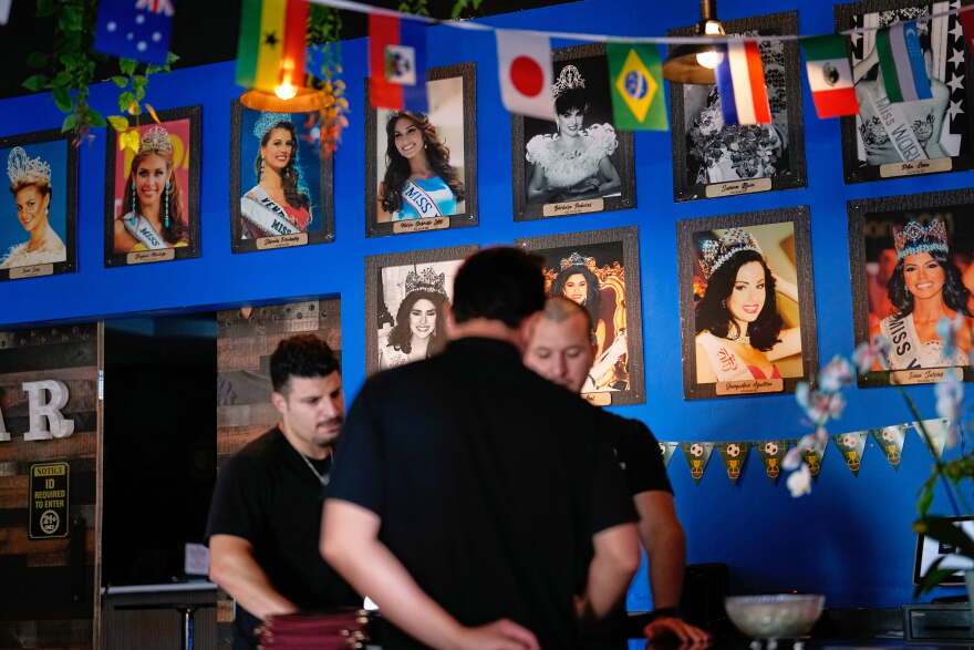 Photos of Venezuelan Miss Universe contestants line a wall at Arempa's restaurant Tuesday, July 14, 2026, in Midvale, Utah.